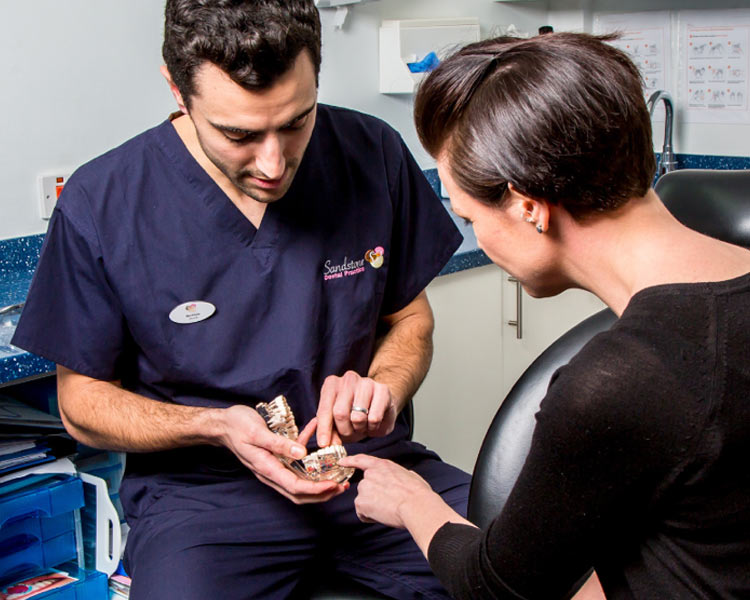 woman and dentist looking at teeth mould
